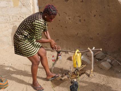 Jennifer Nyaaba, WSMT advocacy team secretary, uses a tippy tap outside her house to wash her hands