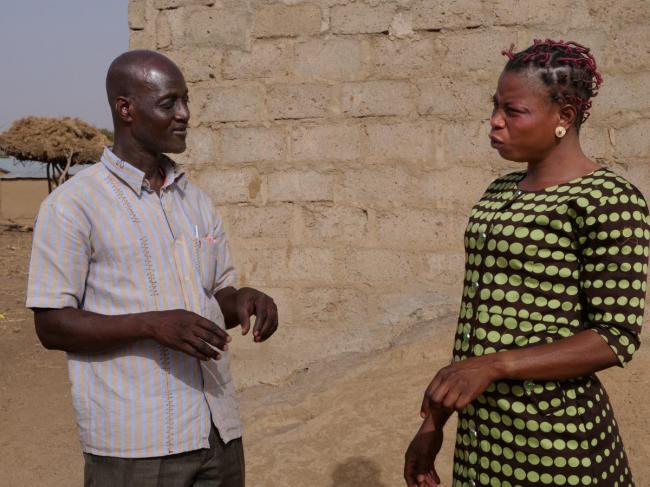 Bongo District Environmental Health Officer Mumuni Abdulai discusses sanitation with Jennifer Nyaaba, a member of the Asaloko Water and Sanitation Management Team
