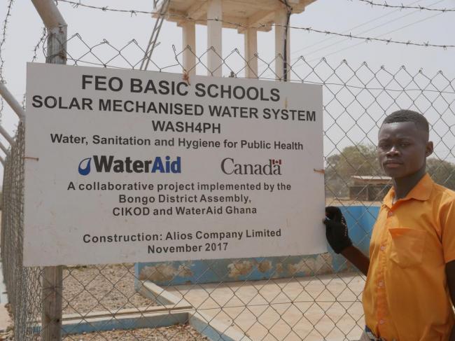 Phileman Azura, aged 15, a student at Foe Junior High School B at the solar mechanised water point installed by WaterAid Ghana and Bongo District Assembly supported by donor money from Canada