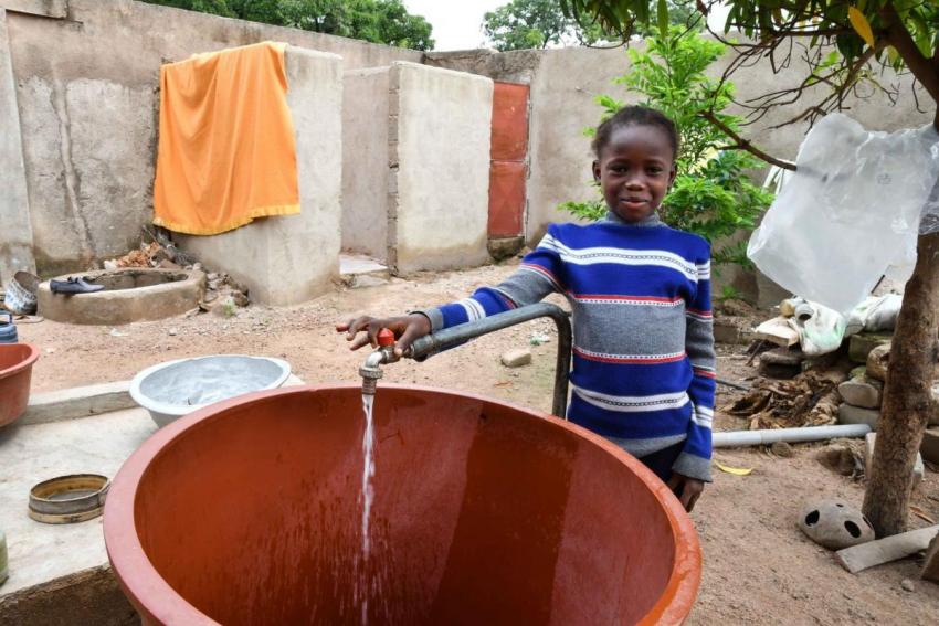 Girl near tap in Burkina Faso
