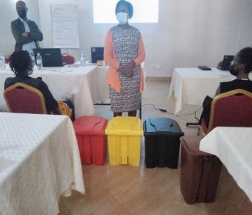 A participant demonstrating waste segregation using coloured bins