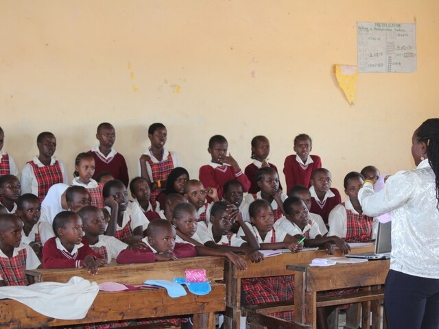 Young girls listening to teacher talking about menstrual hygiene in Kenya