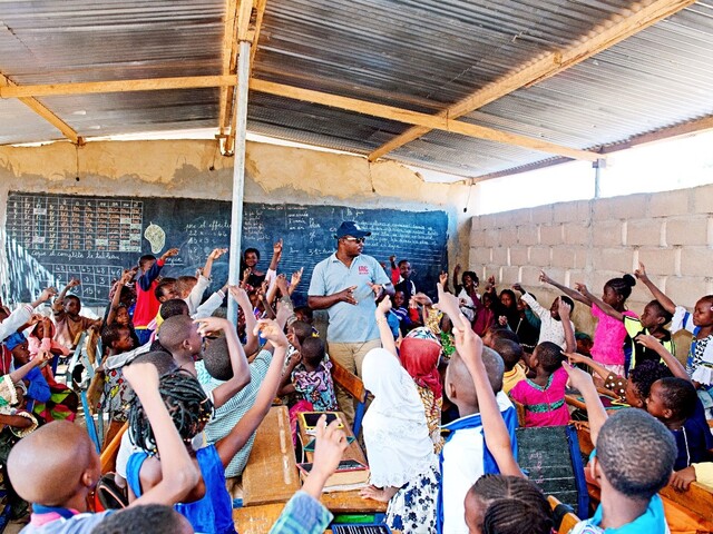 Kids cheering teacher learning about the importance of clean hands in Tenkodogo